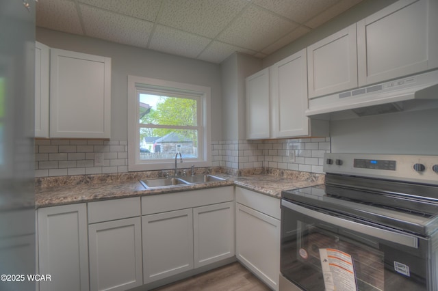 430 Hazel Ave, Lima, OH 45801 - kitchen featuring stainless steel range with electric stovetop, a sink, under cabinet range hood, white cabinets, and a drop ceiling