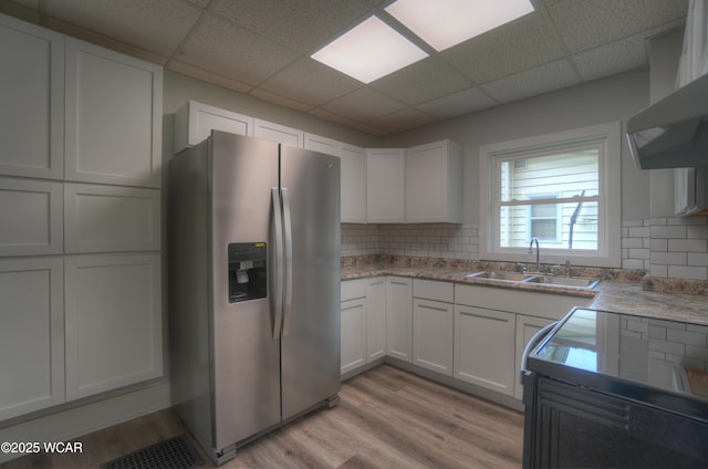 430 Hazel Ave, Lima, OH 45801 - kitchen with stainless steel fridge with ice dispenser, a sink, light wood-style flooring, white cabinetry, and tasteful backsplash