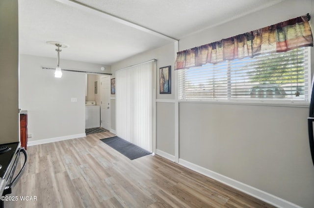 2911 Lakewood Ave, Lima, OH 45805 - unfurnished living room with wood finished floors, baseboards, and washer / dryer