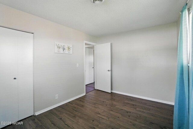 2911 Lakewood Ave, Lima, OH 45805 - unfurnished bedroom with dark wood finished floors, baseboards, and a closet