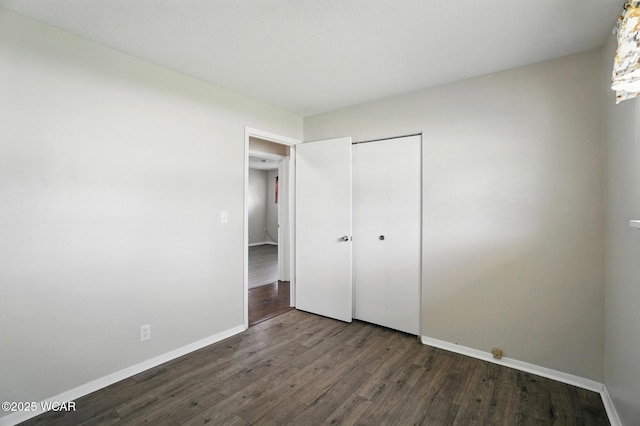 2911 Lakewood Ave, Lima, OH 45805 - unfurnished bedroom with dark wood-style flooring, baseboards, and a closet