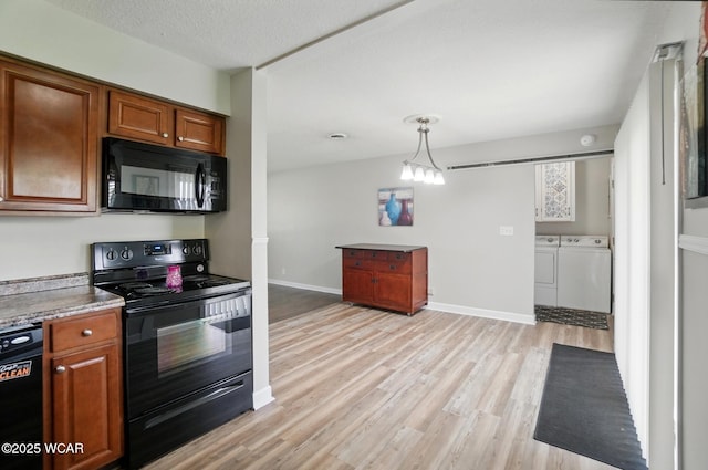 2911 Lakewood Ave, Lima, OH 45805 - kitchen featuring black appliances, washer and dryer, brown cabinets, and light wood-style floors