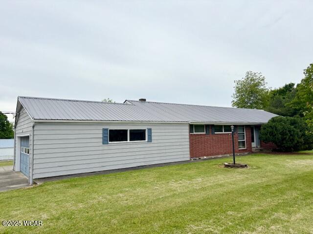 308 Delphos Rd, Columbus Grove, OH 45830 - back of property featuring metal roof, a lawn, and brick siding