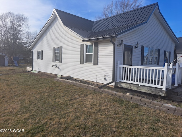 view of side of property with a yard and metal roof