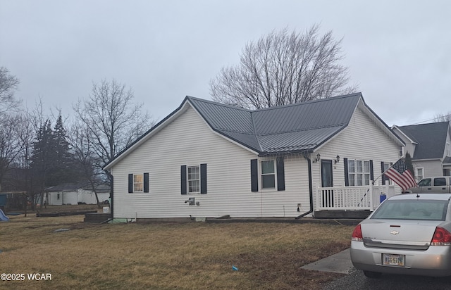 view of property exterior with metal roof and a yard