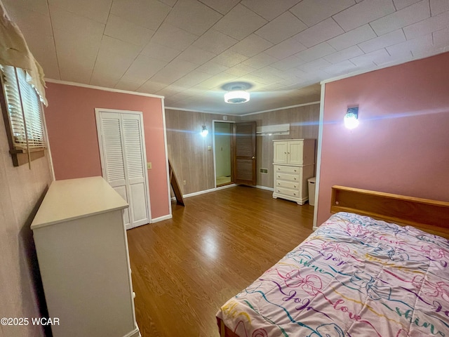 bedroom featuring baseboards, crown molding, and wood finished floors