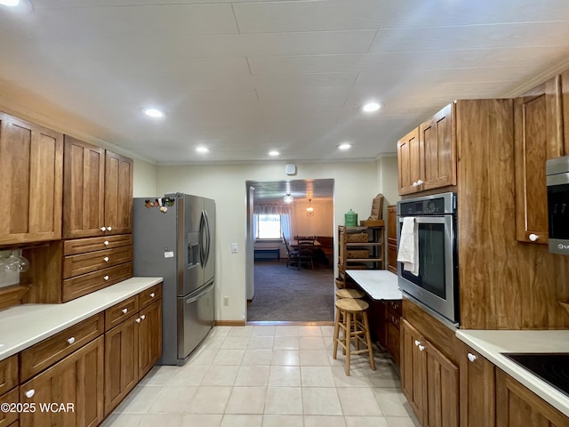 kitchen featuring stainless steel appliances, recessed lighting, light countertops, and brown cabinetry