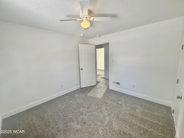 unfurnished bedroom with a textured ceiling, dark carpet, and ceiling fan