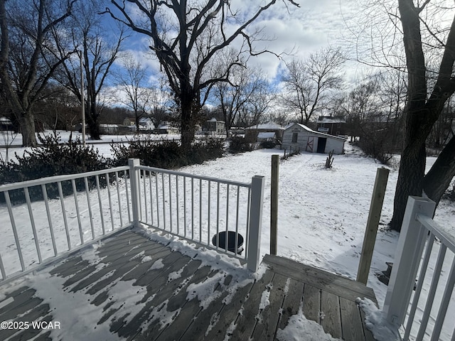 snow covered deck featuring a storage unit