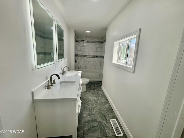 full bathroom with toilet, vanity, and tiled shower / bath