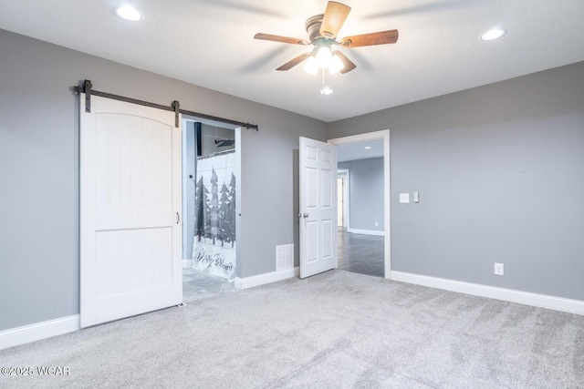 1758 W Hume Rd, Lima, OH 45806 - unfurnished bedroom featuring carpet floors, a barn door, and ceiling fan
