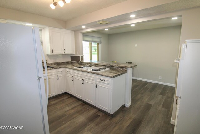 4945 New Haven Dr, Lima, OH 45806 - kitchen with white appliances, a peninsula, dark wood finished floors, white cabinetry, and recessed lighting