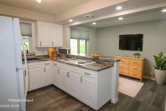 4945 New Haven Dr, Lima, OH 45806 - kitchen with white appliances, a peninsula, healthy amount of natural light, white cabinets, and recessed lighting