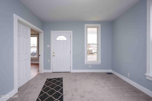 entryway with carpet flooring, baseboards, and visible vents