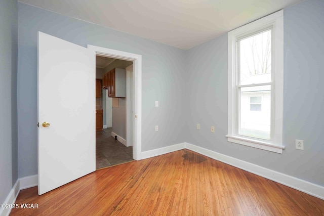 empty room with baseboards and light wood finished floors