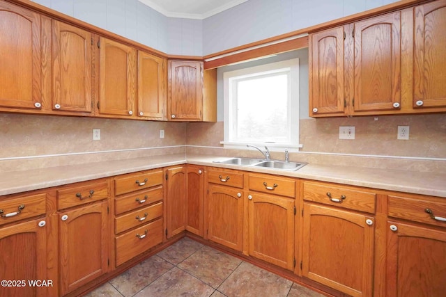 kitchen featuring light countertops, a sink, and brown cabinetry