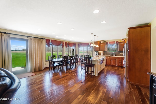 2691 Cremean Rd, Elida, OH 45807 - kitchen featuring freestanding refrigerator, brown cabinetry, a breakfast bar area, dark wood finished floors, and a sink