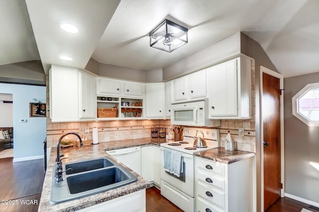 kitchen with white appliances, baseboards, a sink, white cabinetry, and tasteful backsplash