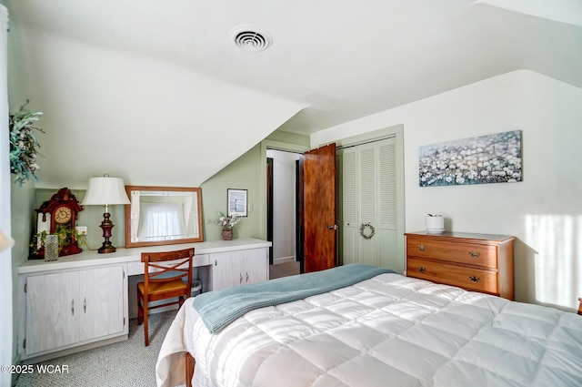 bedroom featuring visible vents, lofted ceiling, light colored carpet, and built in desk