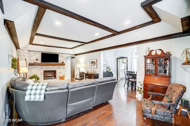 living area featuring beam ceiling, recessed lighting, a large fireplace, and wood finished floors