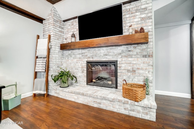 unfurnished living room with baseboards, wood finished floors, and a fireplace