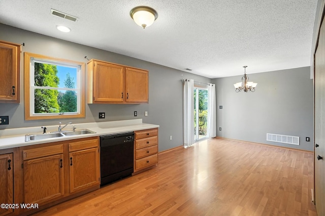 807 Centerfield Dr, Paulding, OH 45879 - kitchen featuring black dishwasher, a textured ceiling, a chandelier, light wood-type flooring, and light countertops