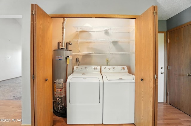 807 Centerfield Dr, Paulding, OH 45879 - laundry room with gas water heater, washing machine and dryer, and light wood-type flooring