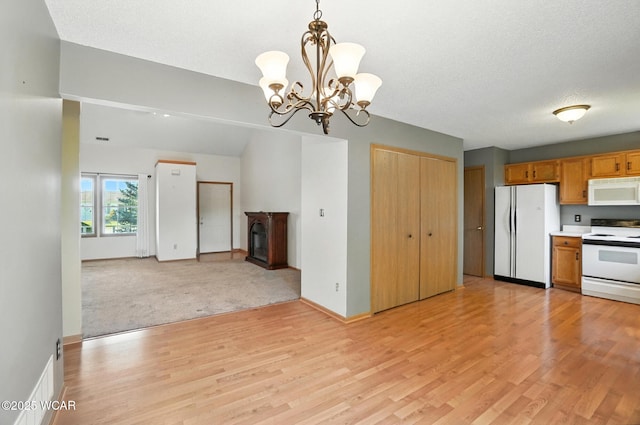 807 Centerfield Dr, Paulding, OH 45879 - kitchen featuring white appliances, a chandelier, light wood-type flooring, decorative light fixtures, and open floor plan