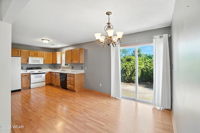 807 Centerfield Dr, Paulding, OH 45879 - kitchen with white appliances, light countertops, a chandelier, light wood-style flooring, and pendant lighting