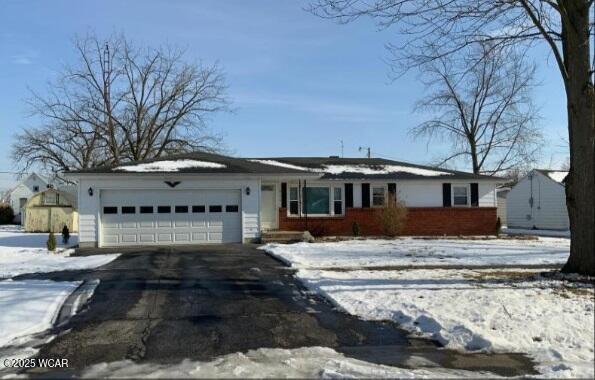 515 N Main St, Paulding, OH 45879 - view of front of home with a garage, driveway, and brick siding