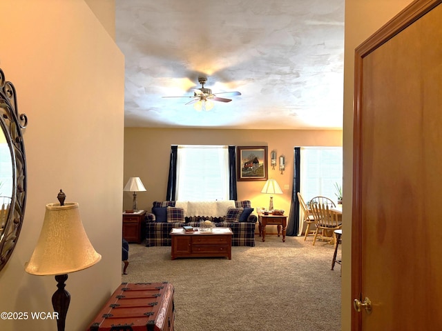 living room featuring ceiling fan and carpet