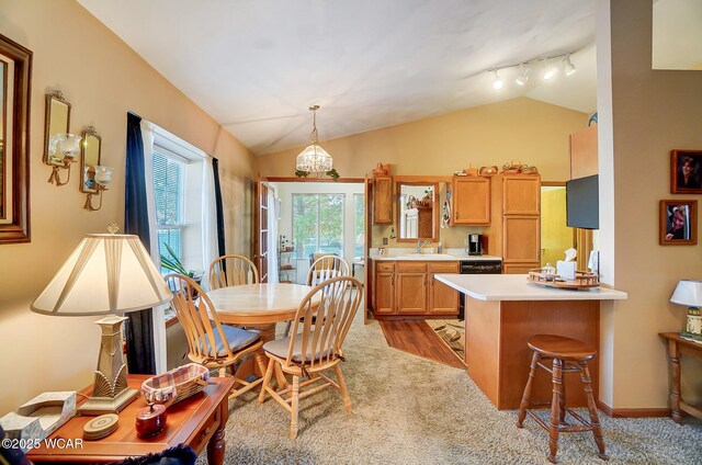 dining area featuring lofted ceiling, light colored carpet, a fireplace, and ceiling fan