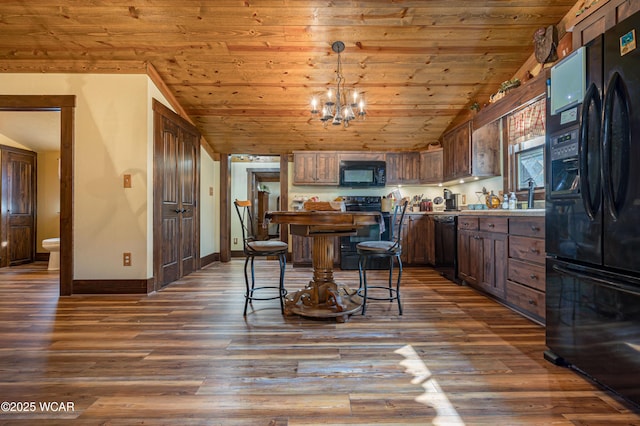 kitchen with dark wood-style flooring, lofted ceiling, wood ceiling, black appliances, and baseboards