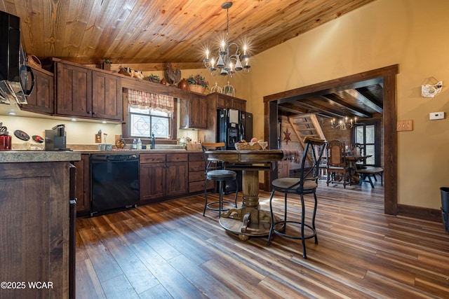 kitchen with black appliances, dark wood-style floors, and an inviting chandelier