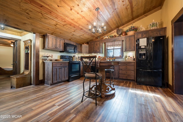 kitchen with dark wood finished floors, an inviting chandelier, wood ceiling, vaulted ceiling, and black appliances