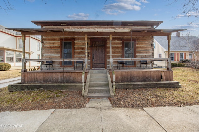 view of front of home featuring covered porch and log exterior