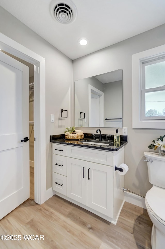 bathroom with vanity, hardwood / wood-style floors, and toilet