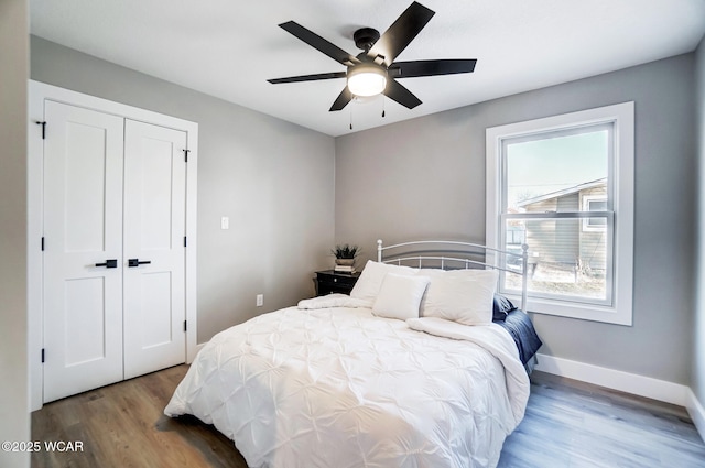 bedroom with hardwood / wood-style flooring, a closet, and ceiling fan