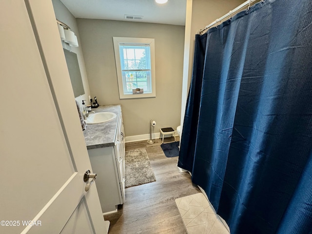111 E Ottawa-Glandorf Rd, Ottawa, OH 45875 - bathroom featuring wood finished floors, visible vents, toilet, vanity, and baseboards
