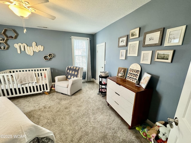 111 E Ottawa-Glandorf Rd, Ottawa, OH 45875 - carpeted bedroom with a nursery area, visible vents, a textured ceiling, and ceiling fan