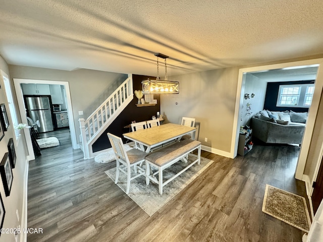111 E Ottawa-Glandorf Rd, Ottawa, OH 45875 - dining area with dark wood-style floors, a textured ceiling, baseboards, an inviting chandelier, and stairway