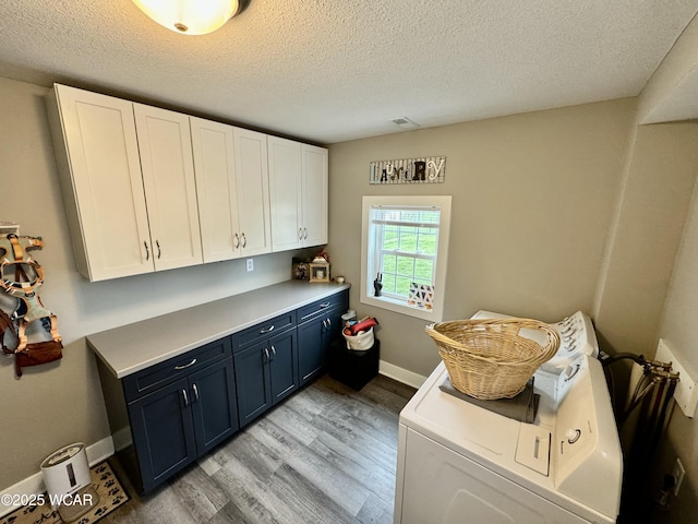 111 E Ottawa-Glandorf Rd, Ottawa, OH 45875 - laundry room with washer / dryer, cabinet space, a textured ceiling, and light wood-style flooring