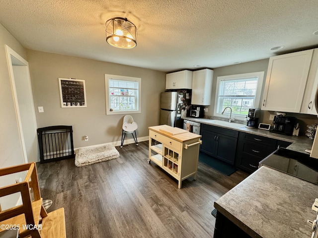 111 E Ottawa-Glandorf Rd, Ottawa, OH 45875 - kitchen with a sink, a textured ceiling, white cabinets, dark wood-type flooring, and freestanding refrigerator