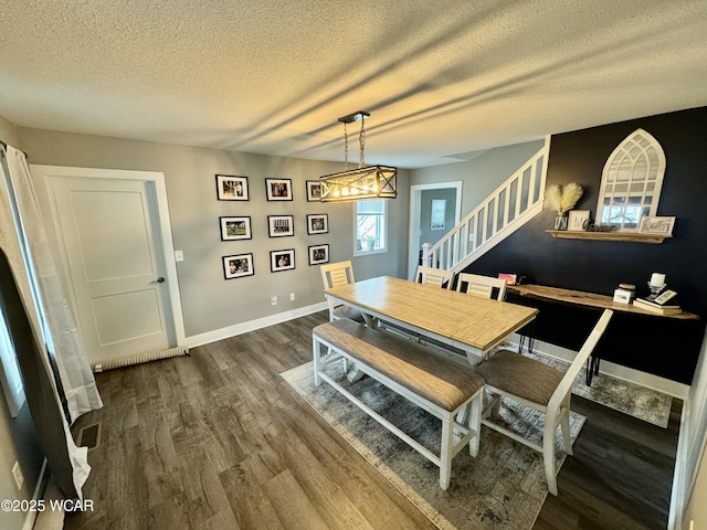 111 E Ottawa-Glandorf Rd, Ottawa, OH 45875 - dining space featuring baseboards, a textured ceiling, stairs, and dark wood-style flooring