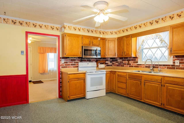 kitchen with electric stove, sink, a wealth of natural light, and ceiling fan