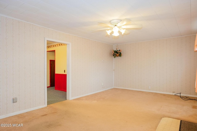 empty room featuring crown molding, ceiling fan, and carpet