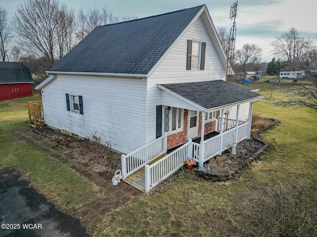 view of side of home featuring a porch and a yard