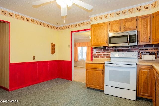 kitchen featuring electric stove, ornamental molding, and ceiling fan