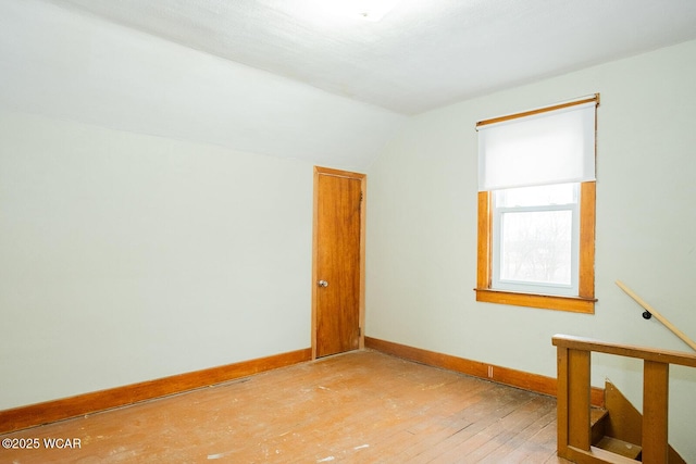 empty room with lofted ceiling and wood-type flooring