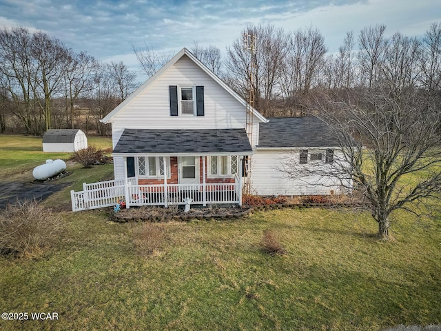 view of front of property featuring a porch, a shed, and a front yard